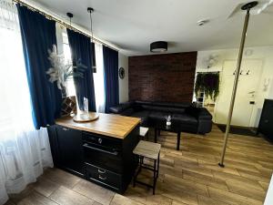a living room with a black couch and a table at Apartament Sienkiewicza in Wrocław