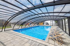 an overhead view of a swimming pool with a metal roof at RResort Holiday Homes - HEATED Swimming Pool & Sauna in Rewal
