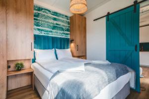 a bedroom with a large bed with a blue door at RResort Holiday Homes - HEATED Swimming Pool & Sauna in Rewal