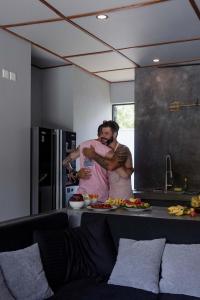 Un uomo e una donna che si abbracciano in cucina di Villa Allure & Villa Ahurewa ad Ahangama