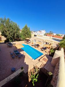 a swimming pool with lounge chairs and a swimming poolvisor at Les Villas de Nouran 7chambres in Ghazoua