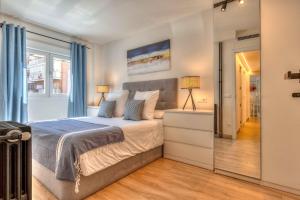a bedroom with a bed with blue curtains at Apartamento Metropolitano II en Madrid in Madrid