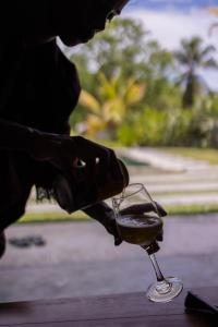 una persona sta tenendo in mano un bicchiere di vino di Villa Allure & Villa Ahurewa ad Ahangama