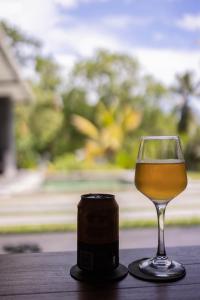 un bicchiere di vino seduto su un tavolo accanto a un barattolo di Villa Allure & Villa Ahurewa ad Ahangama