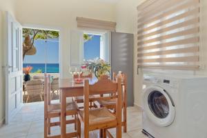 a kitchen with a table and a washing machine at Nikos Studios in Lefkos Karpathou