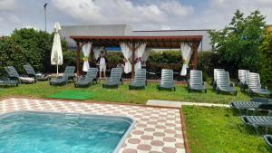 - un groupe de chaises et un kiosque à côté de la piscine dans l'établissement Pensiunea Minerva, à Bistriţa