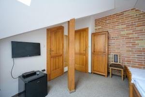 a bedroom with a bed and a tv on a wall at Vinatus Pince in Villány