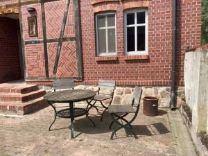 a patio with a table and chairs in front of a brick building at Übernachten im Goethezimmer in Jerchel