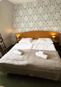 1 dormitorio con 1 cama con 2 toallas en Motel Petro, en Torzym
