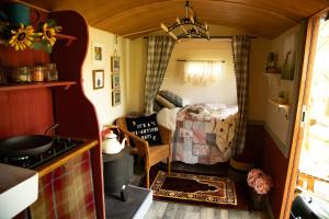 a tiny kitchen with a couch and a table in a room at North Norfolk Glamping in Holt