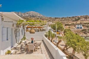 a view from the balcony of a house with tables and chairs at Nikos Studios in Lefkos Karpathou