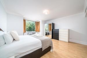 Un dormitorio blanco con una cama grande y una ventana en Luxury St Johns Wood 2-bed with 24hr Concierge, en Londres