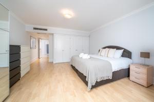 1 dormitorio blanco con 1 cama grande y vestidor en Luxury St Johns Wood 2-bed with 24hr Concierge, en Londres