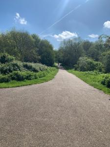 un camino vacío con árboles a un lado en Willowdene Wonder - Corporates & Contractors en Cheshunt