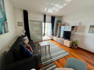 ein Wohnzimmer mit einem Sofa und einem TV in der Unterkunft Apartment Picturesque Retreat in Dramalj