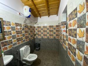 a bathroom with a toilet and a sink at Khushi Cottage in Mukteswar +62 photos