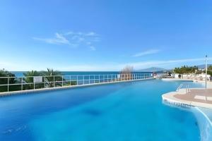 een groot zwembad met de oceaan op de achtergrond bij Stunning unobstructed 180 degree sea view apartment with 100 square meters terrace - Costa del Sol - Estepona in Estepona