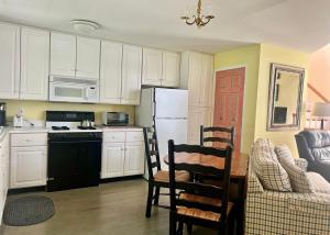 a kitchen with a refrigerator and a table and chairs at The Harpswell Inn in Harpswell Center