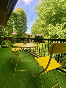 d'une table jaune et de deux chaises sur un balcon. dans l'établissement BORGO TICINO SUITE Attico di Lusso con Terrazzo e Parking Privato, à Pavia