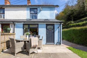 un patio avec une table et des chaises devant une maison dans l'établissement Copper Beech Cottage, à Dulverton
