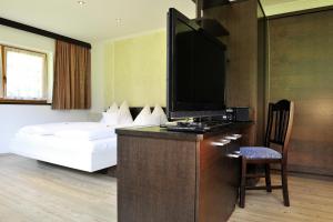 um quarto de hotel com uma cama e uma televisão de ecrã plano em Familienhotel Moos-Alm em Lienz
