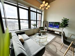 sala de estar con sofá y TV en McCormick Place modern 2br-2ba Loft with optional parking for 6 guests, en Chicago