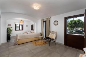 Un dormitorio con una cama y una silla y una ventana. en Harmony Luxury Private Villa 2, en Vourvoúlos