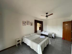 a bedroom with two beds and a ceiling fan at Pousada aconchegante in Jequié