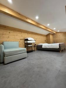 a room with two beds and a couch in it at Les Chalets Perce Neige & Jacuzzi privatif, proximité Gerardmer & La Bresse in Rochesson