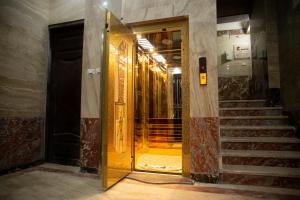 uma porta dourada num corredor com escadas em Gardenia Apartment Pyramids View em Cairo