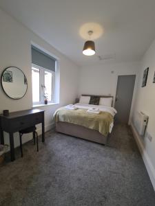 a bedroom with a bed and a desk and a mirror at Cosy 1 Bedroom Apartment in Mytholmroyd