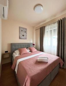 a bedroom with a pink bed with a pink blanket at Apartment Mate in Pridraga