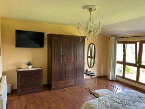 a bedroom with a bed and a dresser and a television at Casa La Güelina en Asturias VUT-3276-AS in Arriondas