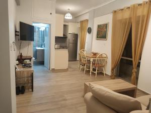 a living room with a table and a kitchen at Sea & Chess Apt Rental in Chania