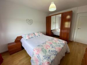 Schlafzimmer mit einem Bett, einer Kommode und einem Spiegel in der Unterkunft Increíbles Vistas a la Ría de Mogro in Miengo