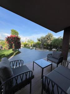 a patio with tables and chairs and a view of a street at SunnySide Private Riverside Villa in Draç