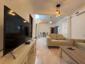 a living room with a large flat screen tv at Mokawa BnB Stone Town in Ngambo