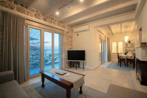 カリムノスにあるMyloi Luxury Villa Kalymnosのリビングルーム(テレビ、大きな窓付)