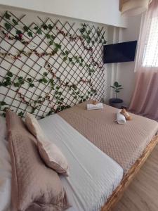 a bed in a bedroom with a wall with flowers at IL TRAMONTO APARTMENT 1 in Kanali