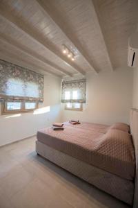 カリムノスにあるMyloi Luxury Villa Kalymnosのベッドルーム1室(ベッド1台、窓2つ付)