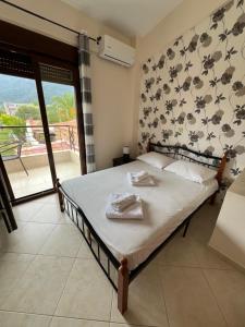 a bedroom with a bed and a balcony at Penelope's Maisonette in Skala Potamias