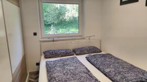 Ce lit se trouve dans une petite chambre dotée d'une fenêtre. dans l'établissement Moderne-Ferienwohnung-nur-1km-vom-Millstaetter-See-in-Kaernten-entfernt, à Millstatt