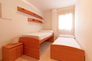 two beds in a small room with a window at Global Properties, Apartamento con terraza de 70m y piscina en Canet de Berenguer in Canet de Berenguer