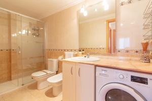 a bathroom with a toilet sink and a washing machine at Global Properties, Apartamento con terraza de 70m y piscina en Canet de Berenguer in Canet de Berenguer +28 photos