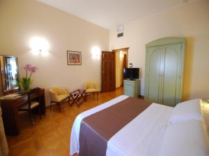 Alla Rocca Hotel Conference & Restaurant في Bazzano Bologna: غرفة فندقية بسرير وطاولة وكراسي