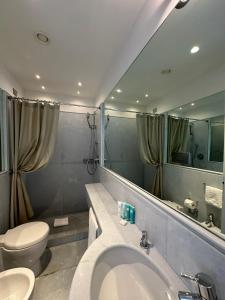 a bathroom with a sink and a toilet and a mirror at Hotel Miramare - Adults Only in Trieste +37 photos