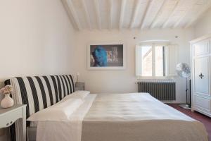 a white bedroom with a bed and a window at Borgo Serenità in Laiatico +33 photos