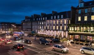 a busy city street with cars and buildings at night at Courtyard by Marriott Edinburgh in Edinburgh