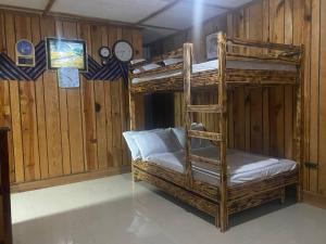 Cette chambre comprend 2 lits superposés et une horloge. dans l'établissement Baguio mountain villa view RW, à Baguio