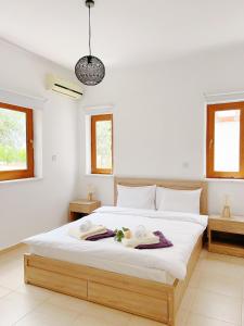 una camera da letto con un grande letto con asciugamani di White Mountain Pool Villas a Paphos